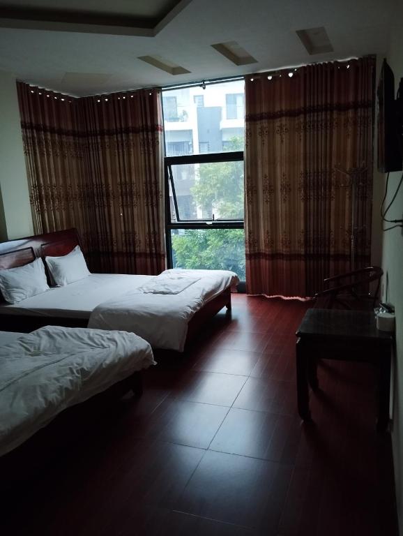 1 dormitorio con 2 camas y ventana grande en Thảnh Đạt Motel, en Hai Phong