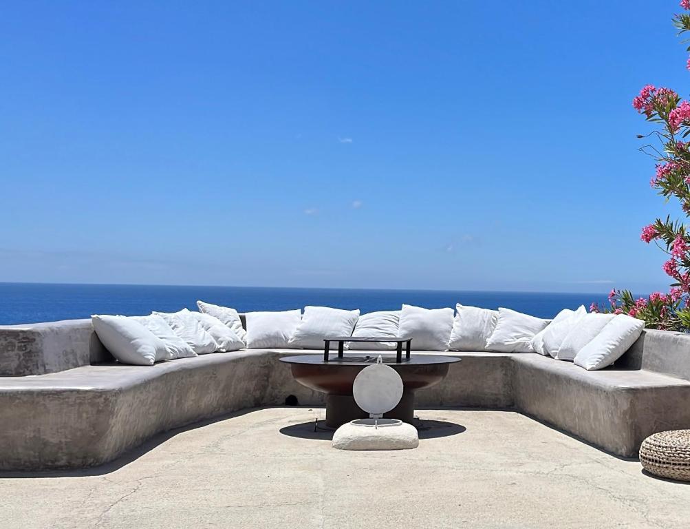 un divano con cuscini e un tavolo di fronte all'oceano di Dammuso dei Turchi by the ocean a Tracino