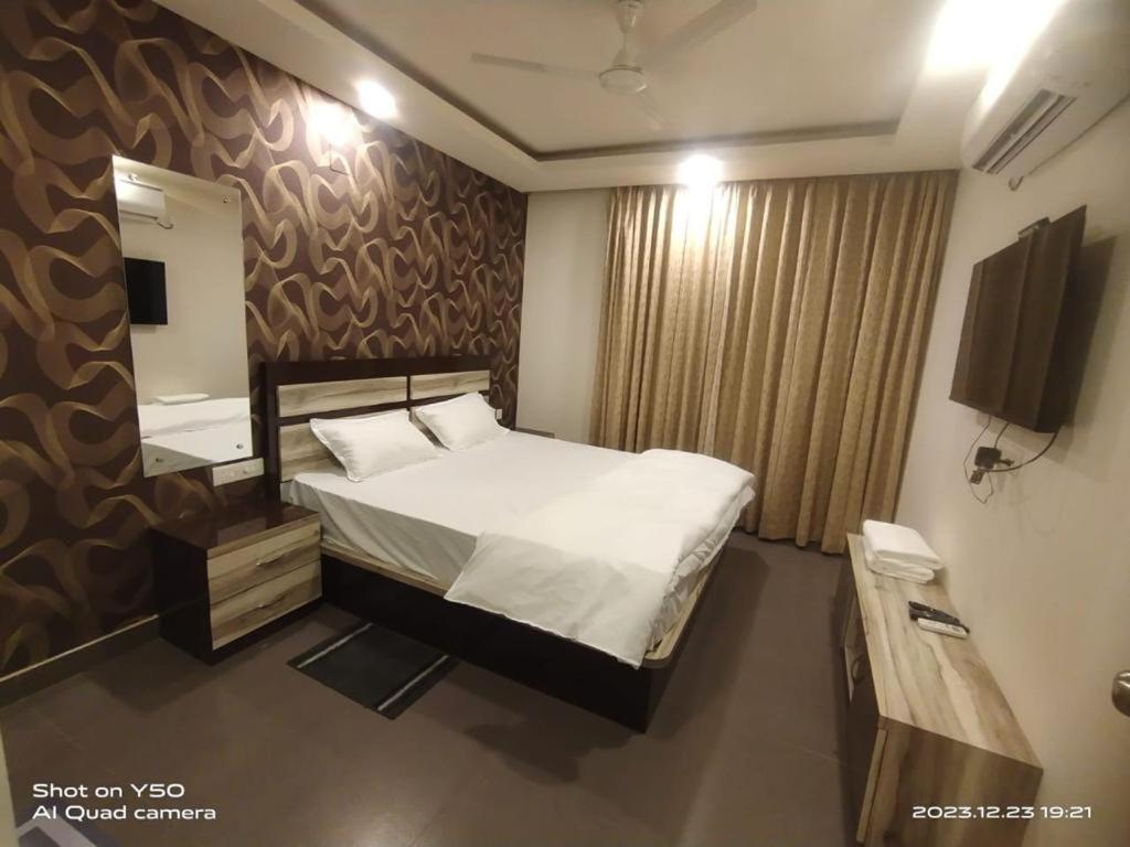 um quarto com uma cama grande e um espelho em ANANYAA BEACH STAY em Puri