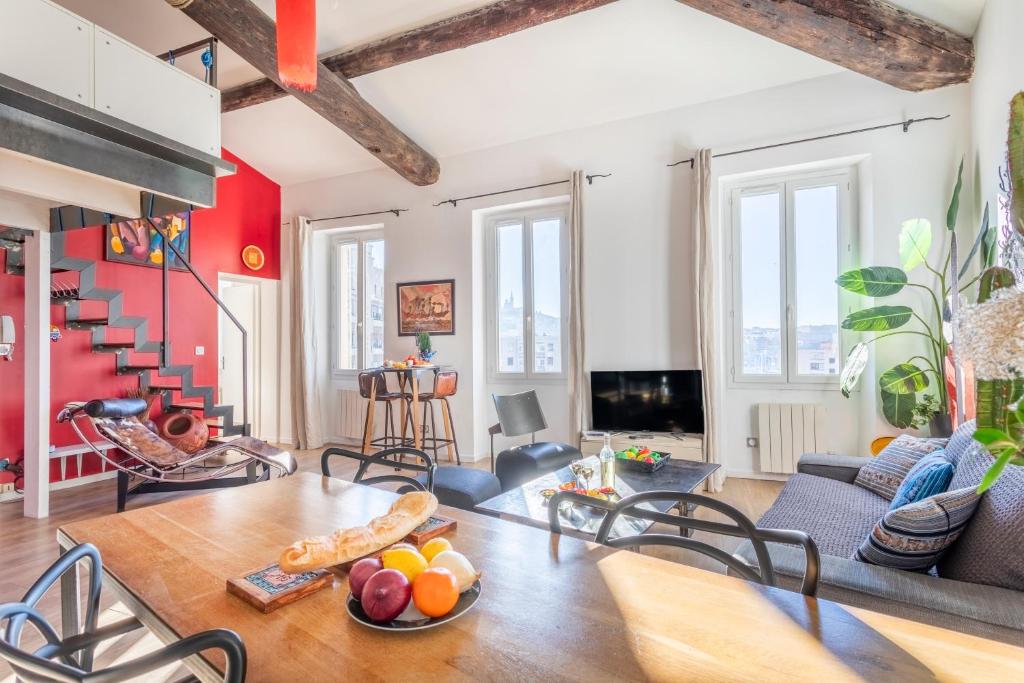 ein Wohnzimmer mit einem Tisch und Stühlen in der Unterkunft Le Loft du Panier Design Central Vue imprenable in Marseille