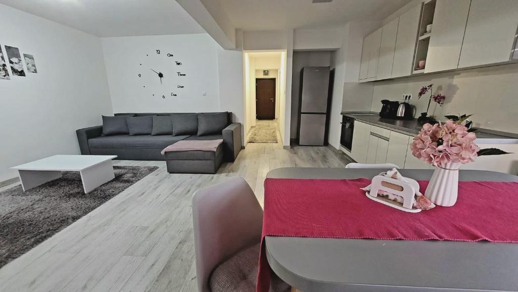 Fortuna Park Apartman في سفنتو جيورجي: غرفة معيشة مع أريكة وطاولة مع زهور