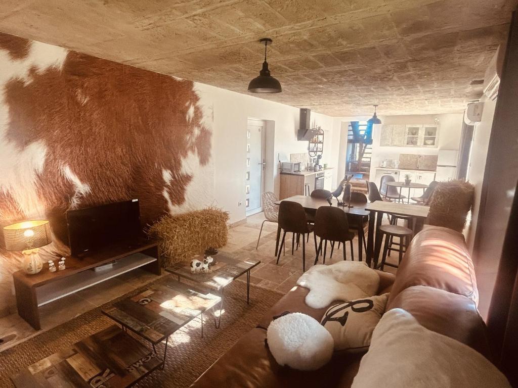 ein Wohnzimmer mit einem Sofa und einem Tisch in der Unterkunft LA MARIEFACTURE - Comme à La Ferme 