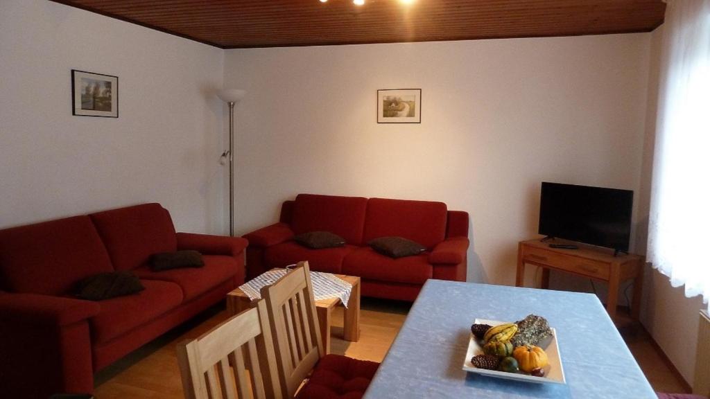 uma sala de estar com um sofá vermelho e uma mesa em Hase em Eslohe