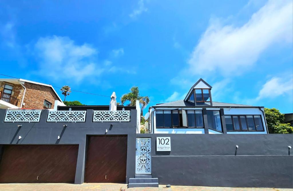 a house with a garage and a sign on it at Mosselbay Dream Home in Mossel Bay