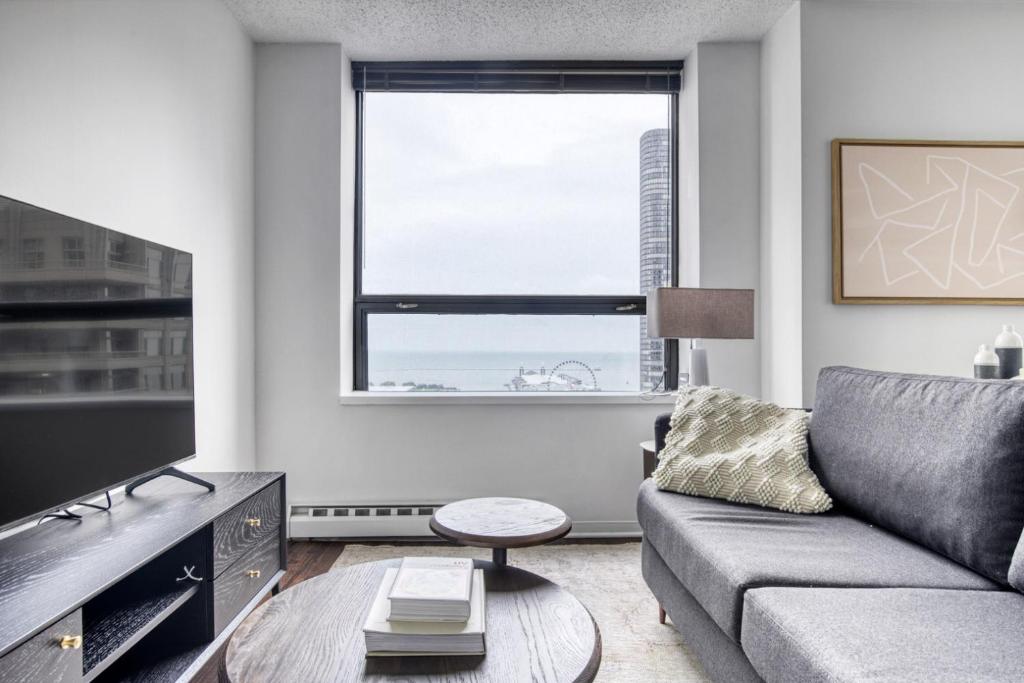 a living room with a couch and a large window at Streeterville Studio w Gym Pool nr Navy Pier CHI-450 in Chicago