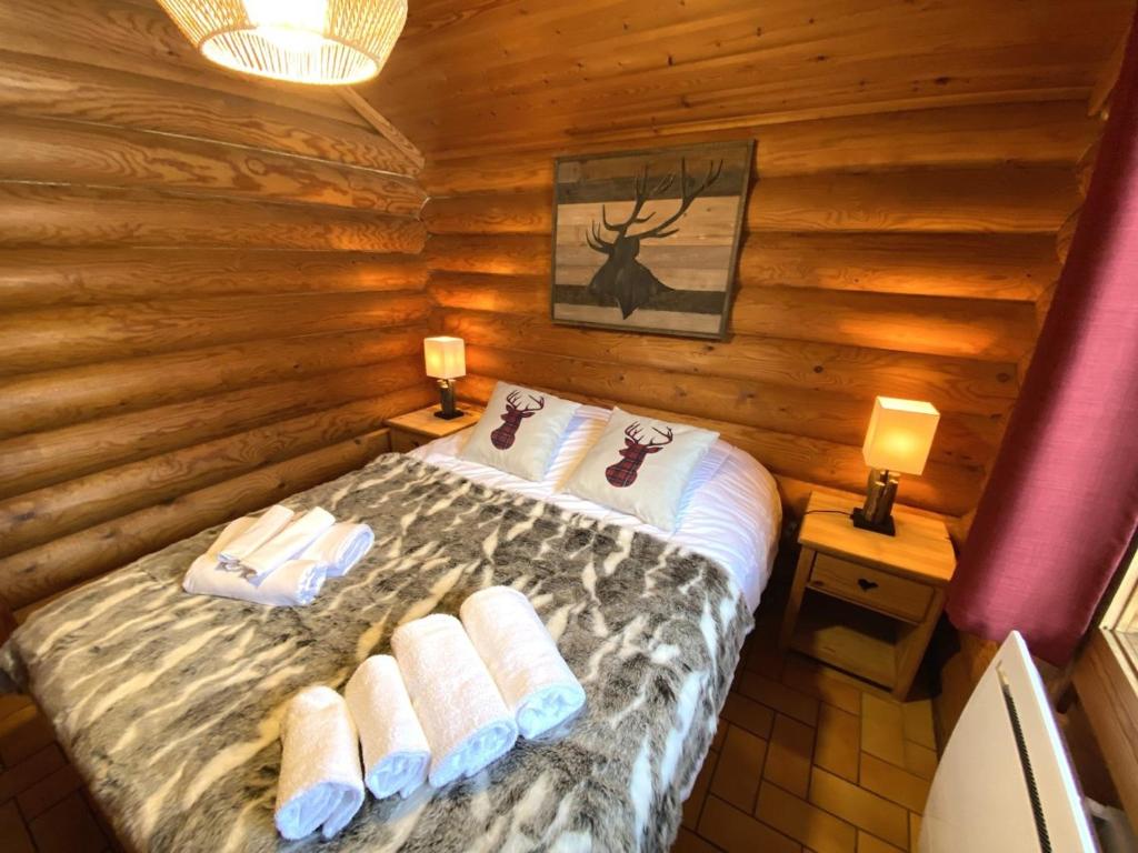 a bedroom with a bed in a log cabin at LE GRAND CERF Chalet en rondins avec SPA Jacuzzi in La Bresse
