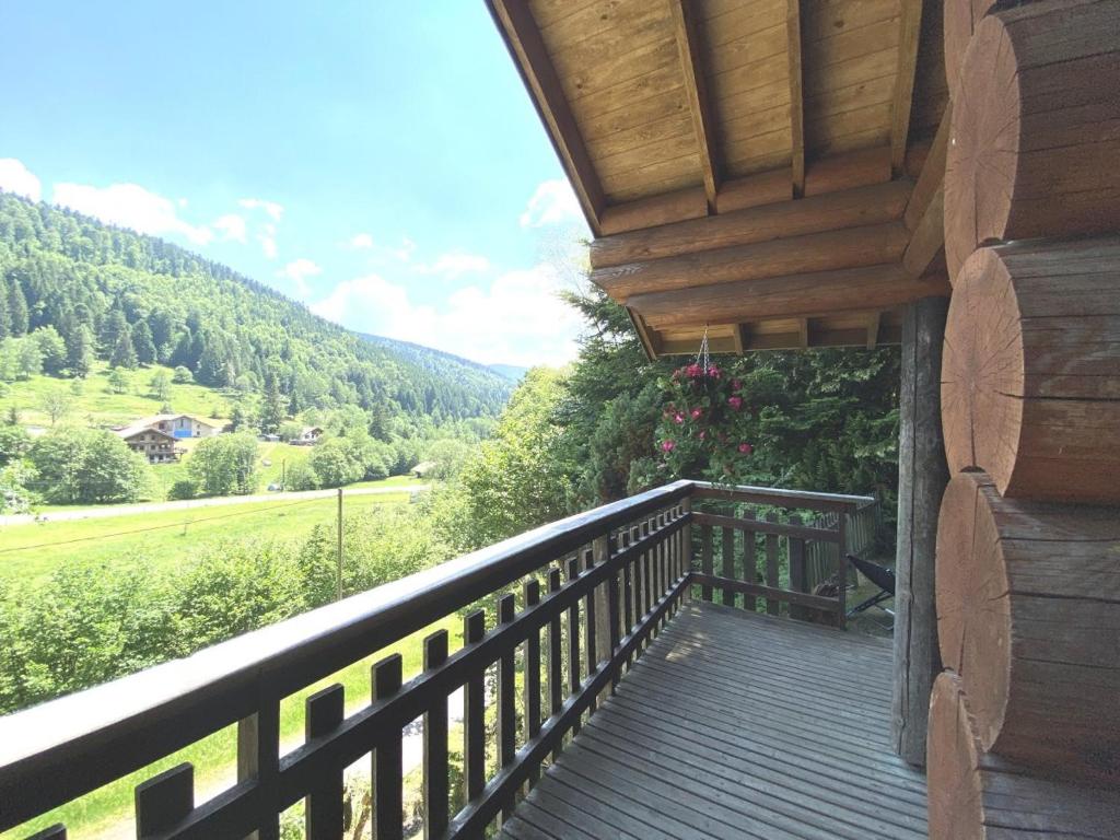 a balcony of a house with a view of the mountains at LE GRAND CERF Chalet en rondins avec SPA Jacuzzi in La Bresse