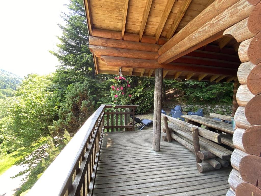 a wooden porch with a wooden bridge with flowers on it at LE GRAND CERF Chalet en rondins avec SPA Jacuzzi in La Bresse