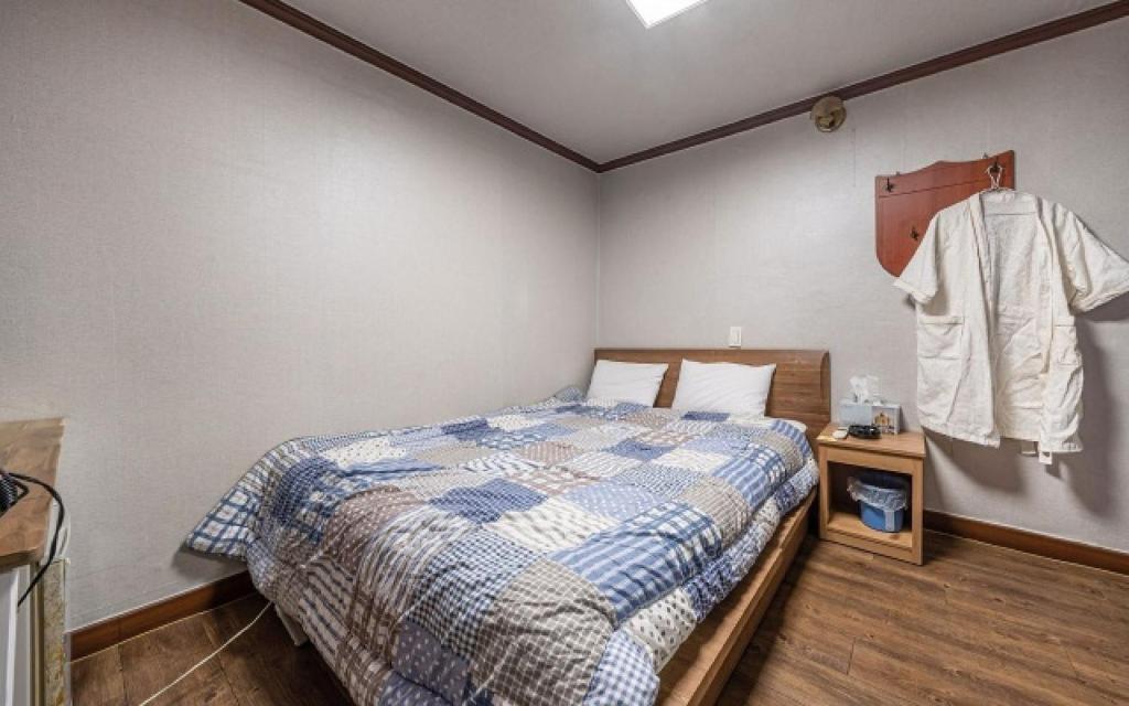 1 dormitorio con 1 cama y 1 camisa colgada en la pared en GwiBinJang Motel, en Paju