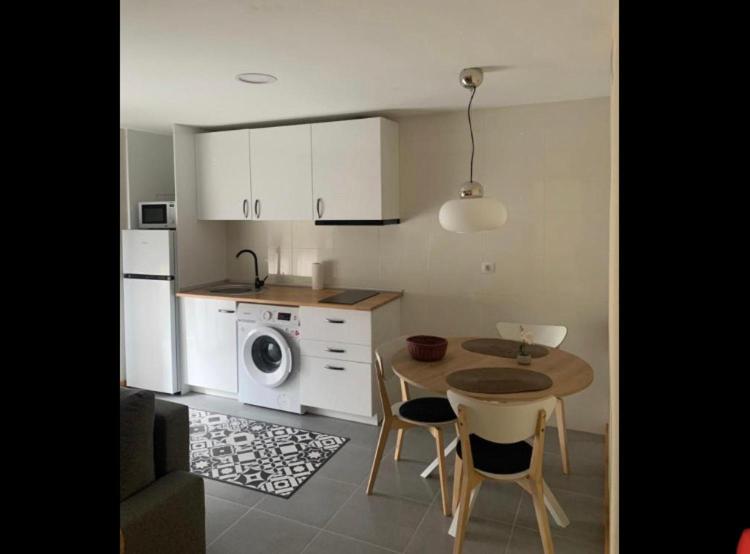 uma cozinha com uma mesa e uma cozinha com uma máquina de lavar roupa em Casa Cristina - Rioja - I em Cenicero