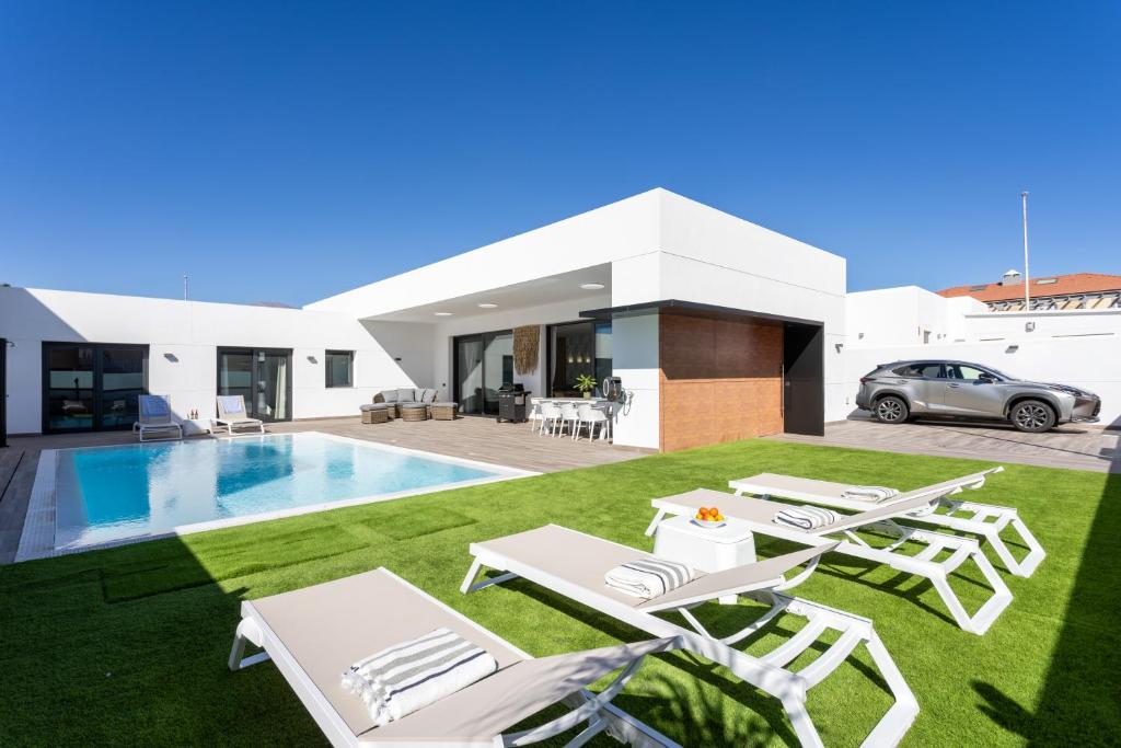 埃爾梅達諾的住宿－Villa Ikigai By Sunkeyrents，一座带游泳池和草坪的别墅