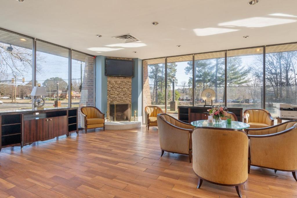 a dining room with a table and chairs and a fireplace at Williamsburg Suites in Williamsburg