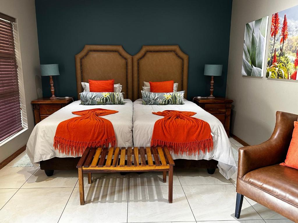a bedroom with a large bed with orange pillows at Meyers Guesthouse in Jwaneng