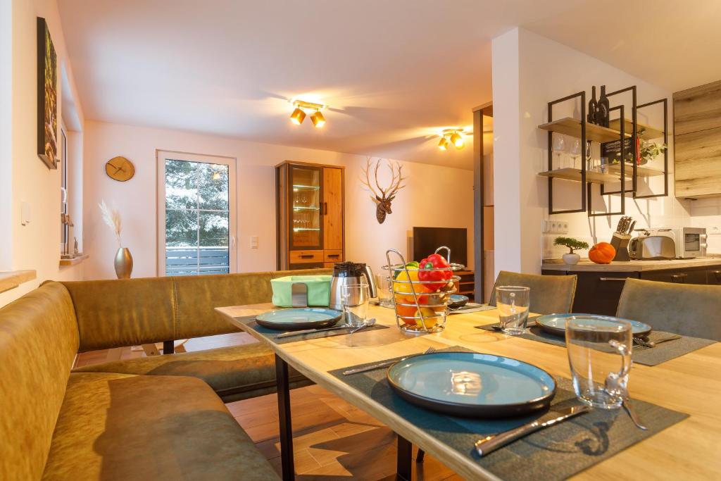 - une salle à manger avec une table et un canapé dans l'établissement Ferienhaus am Wald, à Wernigerode