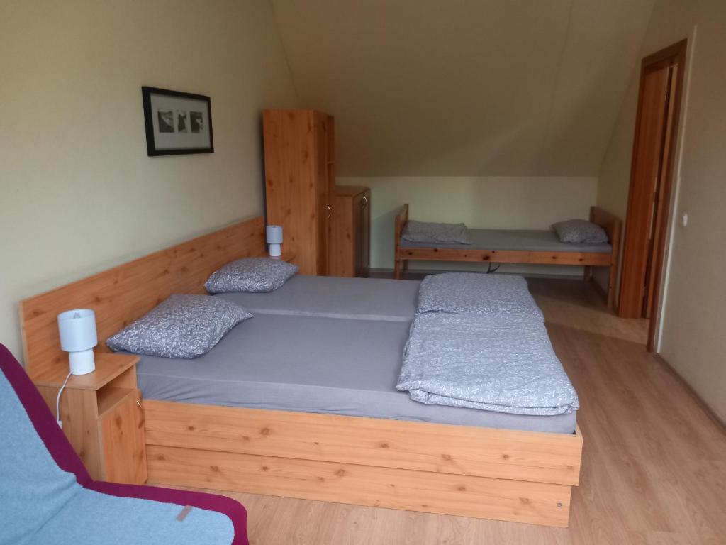 A bed or beds in a room at Forrás Vendégház