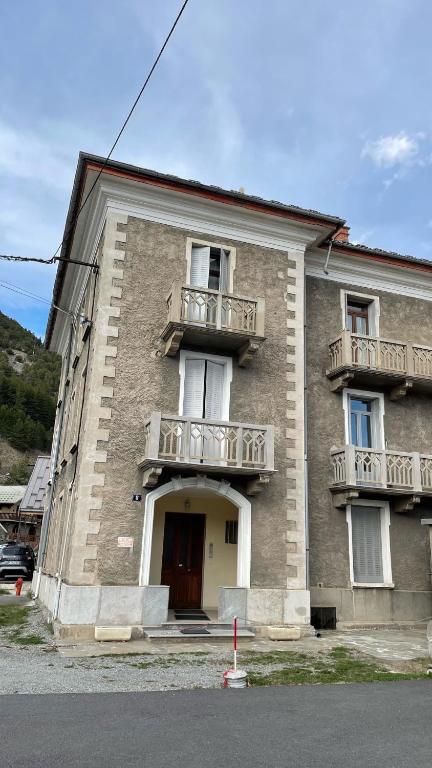 un grand bâtiment en briques avec des balcons et une porte dans l'établissement Repos, Cité Vauban., à Briançon