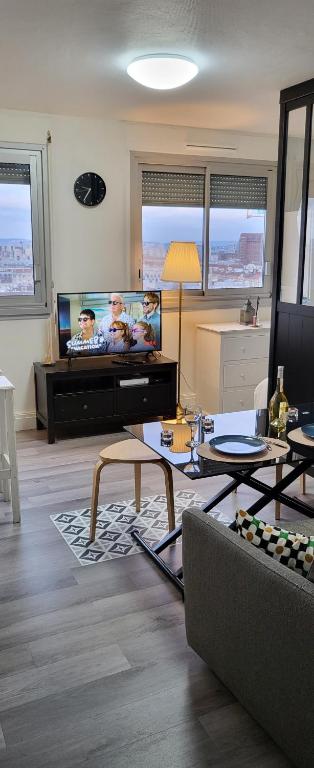 un salon avec un canapé et une télévision à écran plat dans l'établissement LOGEMENT CLICHY, à Clichy