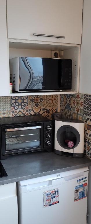 a kitchen with two microwaves and a microwave at LOGEMENT CLICHY in Clichy