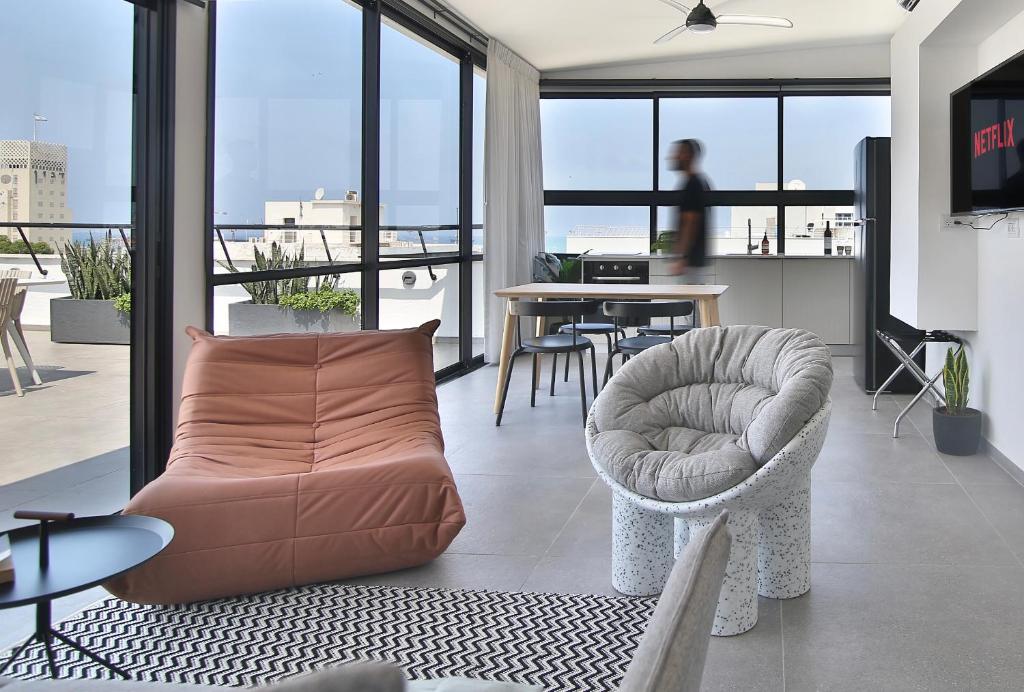 a living room with a couch and a chair at ROOFTOP 42 - Penthouse in Haifa