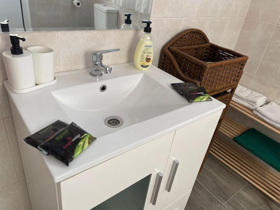 - un lavabo blanc dans la salle de bains avec un panier dans l'établissement Alojamiento Rural Los Corrales, à Algodonales