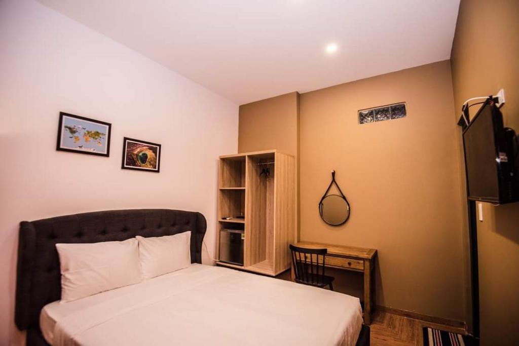 a bedroom with a bed and a desk and a television at 1991 Boutique Hotel in Phan Thiet