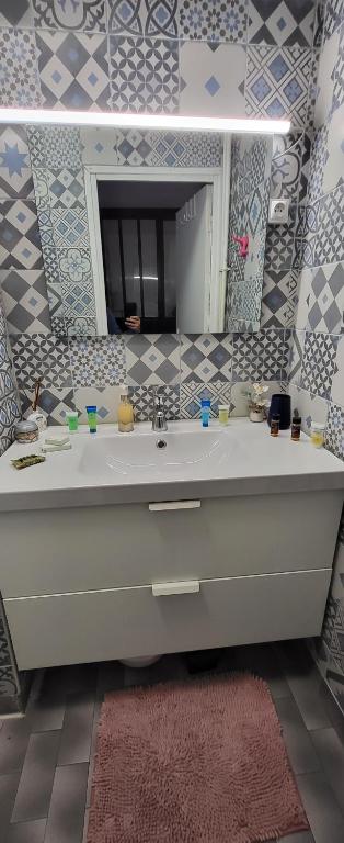 a bathroom with a sink and a mirror at LOGEMENT CLICHY in Clichy
