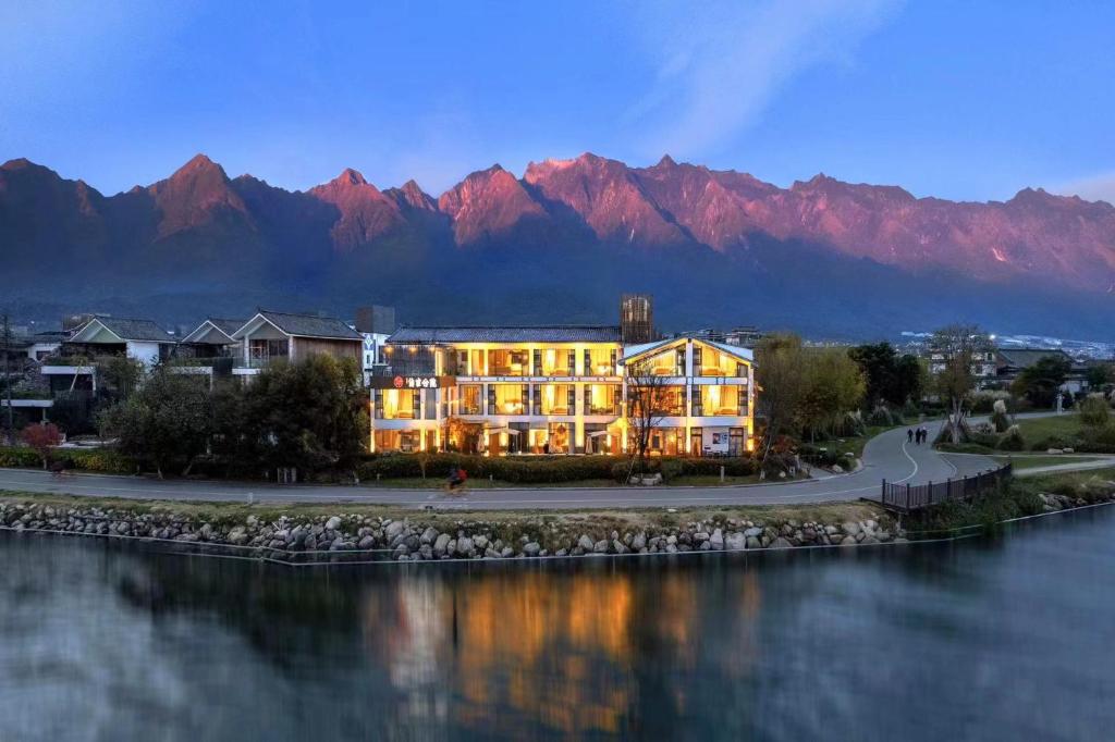 a building next to a body of water with mountains at Dali Beauty Seaview B&B in Dali