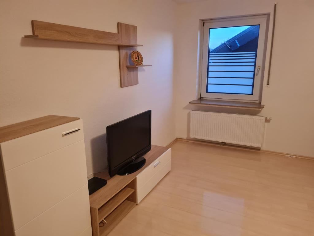 een woonkamer met een tv en een raam bij Oli-DGR, Monteurwohnung in Geeste