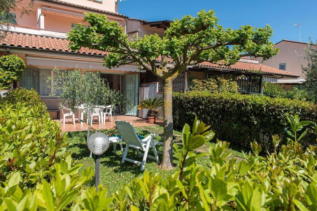 um jardim com uma mesa e cadeiras e uma árvore em M355 - Marcelli, bilocale con giardino e parcheggio em Marcelli