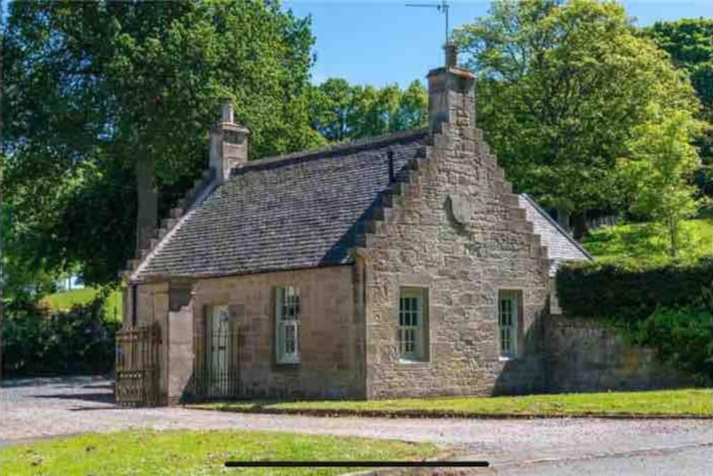 an old stone house sitting on top of a field at The Gate House - 3 Bed & Parking in Edinburgh