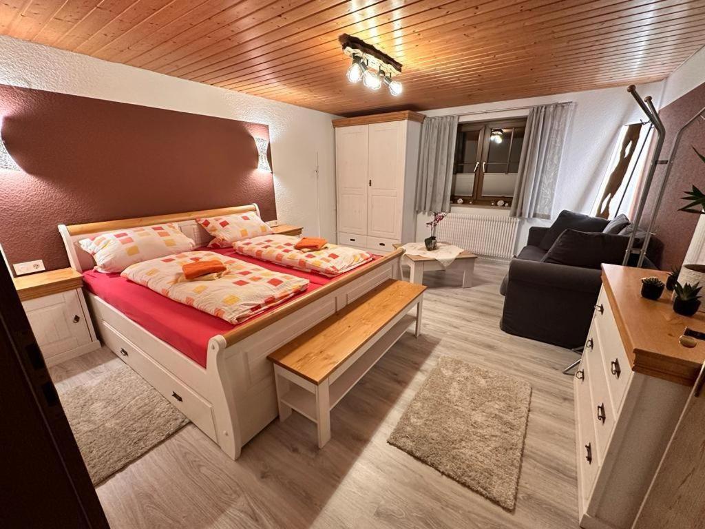 a bedroom with a bed and a living room at Ferienhof-Gerda-Ferienwohnung-Schwalbennest in Oberkirnach