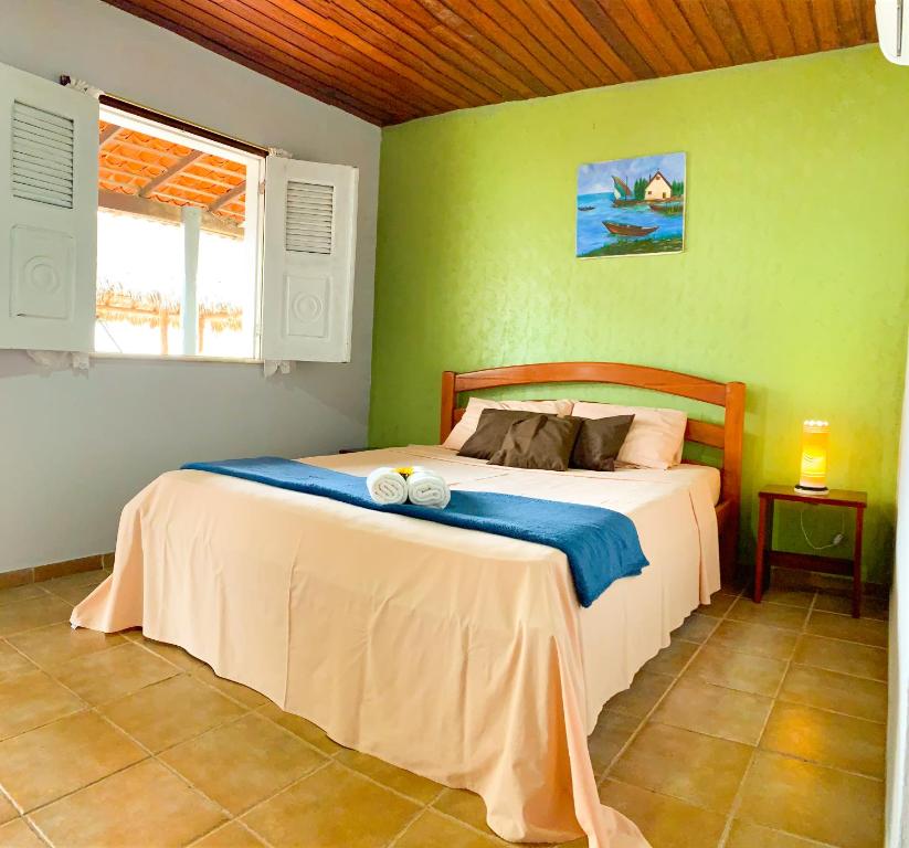 1 dormitorio con 1 cama en una pared verde en Paraíso das Canárias, en Araioses