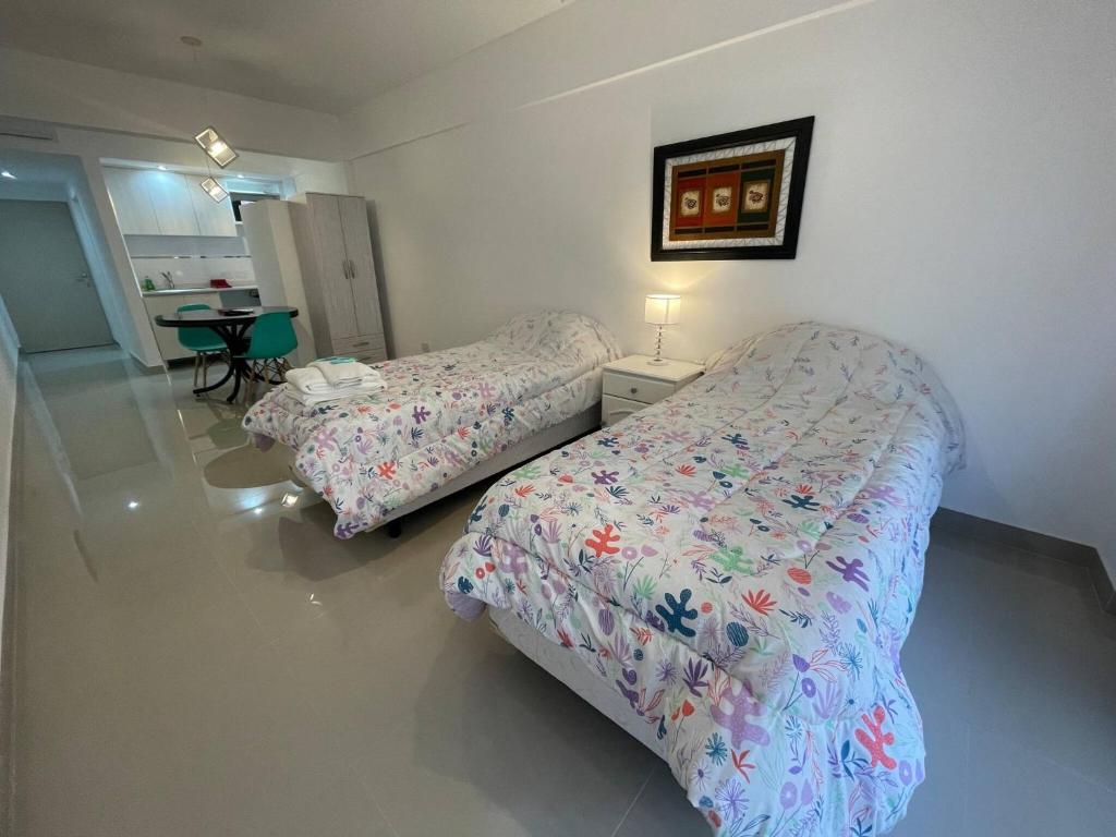 Luxury in San Telmo - Paseo de la Cisterna num6187 في بوينس آيرس: غرفة نوم بسريرين وطاولة فيها