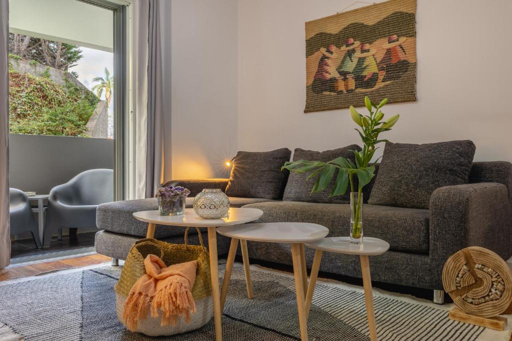 - un salon avec un canapé et deux tables dans l'établissement Kaizen Home & Pool, à Funchal