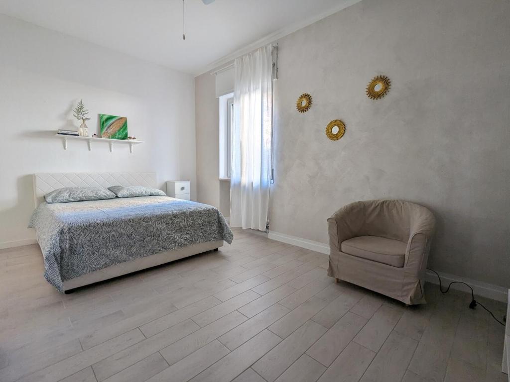 a bedroom with a bed and a chair at Bardolino Center Apartments in Bardolino