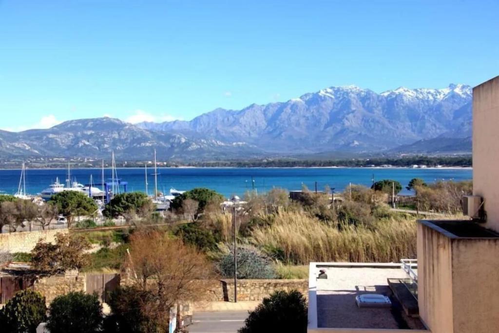 een uitzicht op het water en de bergen vanuit een gebouw bij Centru Appart lumineux vue mer 5 min à pied de la plage et du centre in Calvi