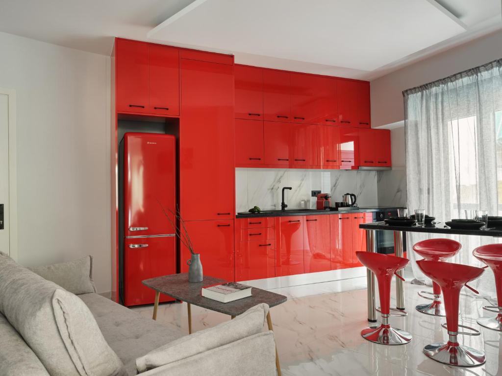 a red kitchen with red cabinets and red stools at Athens Project Luxury Apartments in Athens