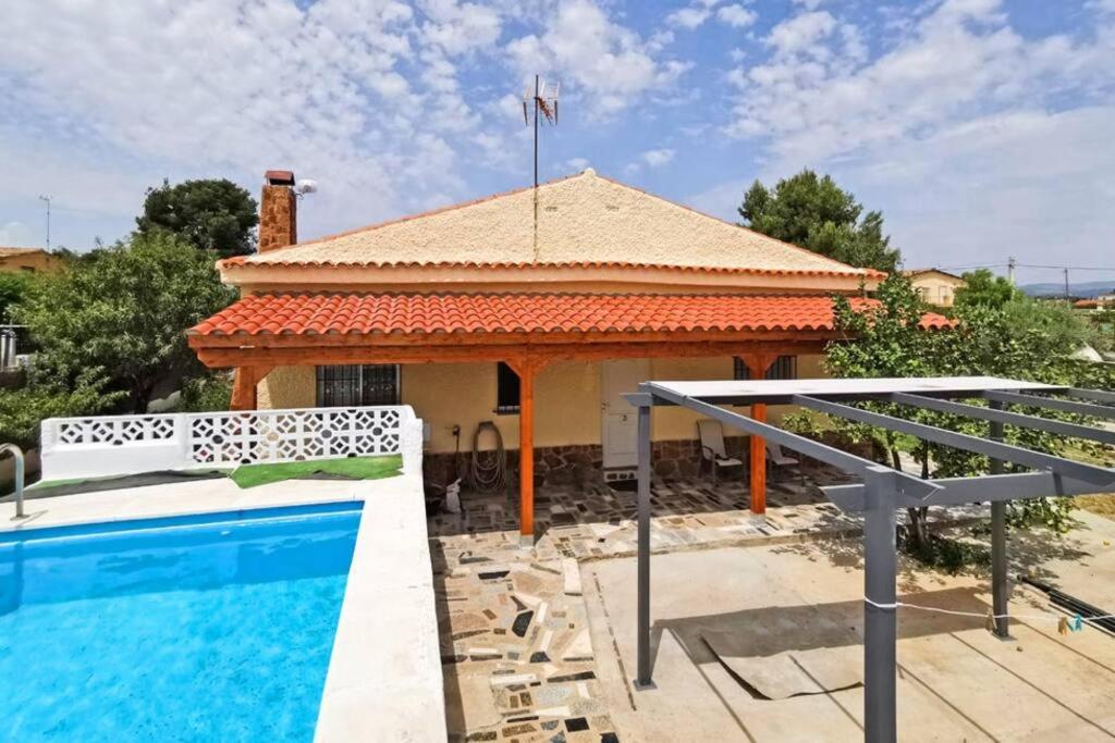 a villa with a swimming pool in front of a house at Charming Villa in Lliria w/ Private Pool & Garden in Lliria