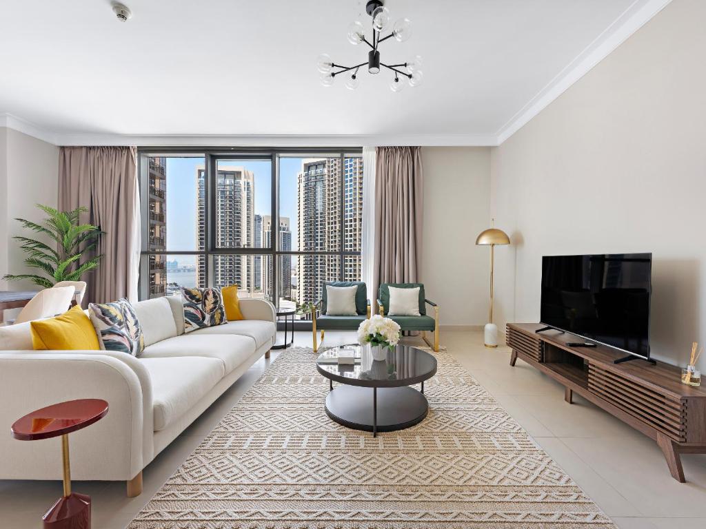 a living room with a white couch and a tv at Brand New Spacious 2BDR Dubai Creek Residences - South in Dubai