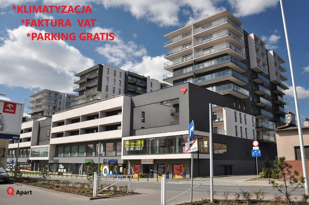 a large apartment building with a parking garage at Q Apart AGAT - parking klimatyzacja, FV, STUDIO in Łódź