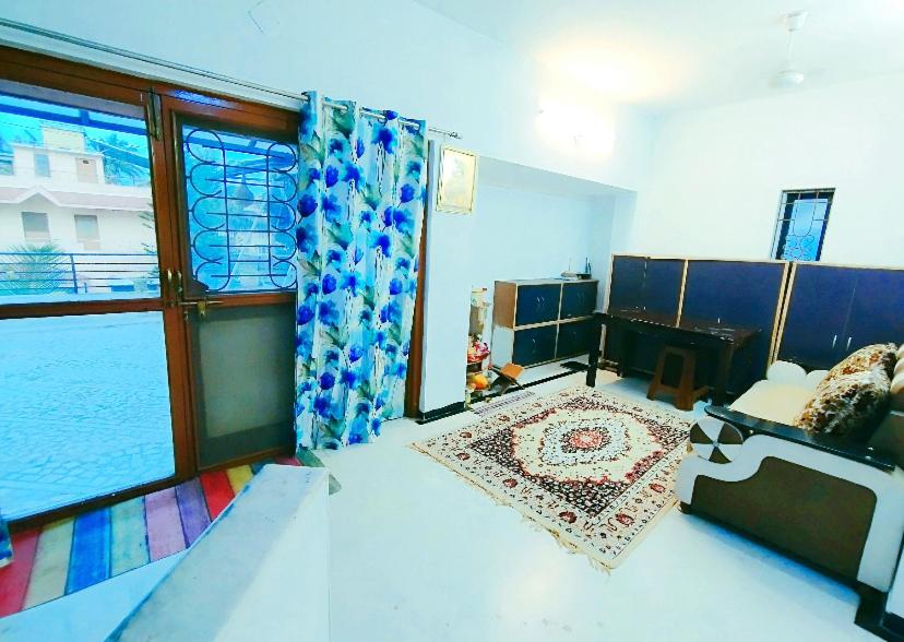 - un salon avec un canapé et une grande fenêtre dans l'établissement Aashiyana, à Nashik