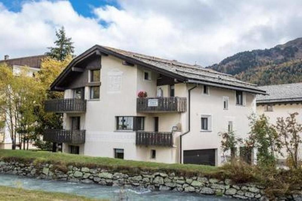 a large white building with balconies and a river at Chesa Margretta, 3 ZWG im Obergeschoss in Sils Maria