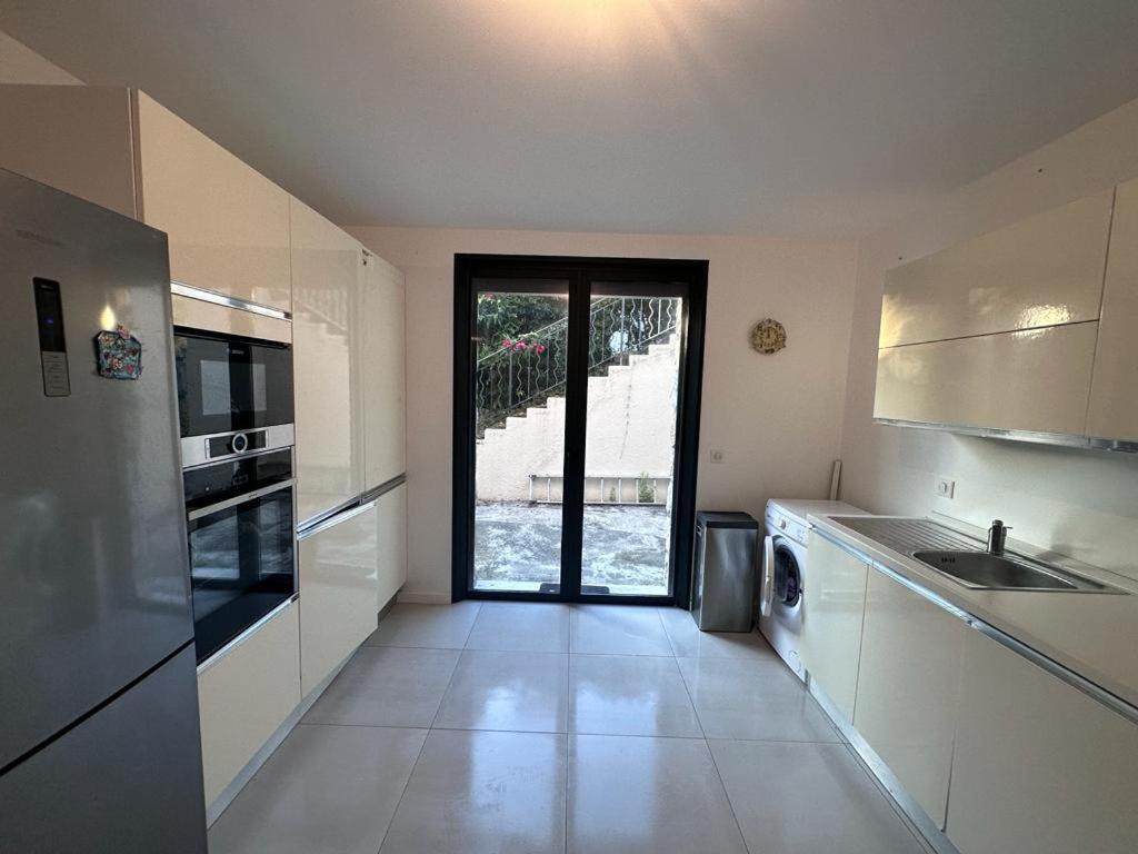 une cuisine avec un évier et une cuisinière four supérieur dans l'établissement Magnifique Bas de villa entièrement indépendant, à Cannes