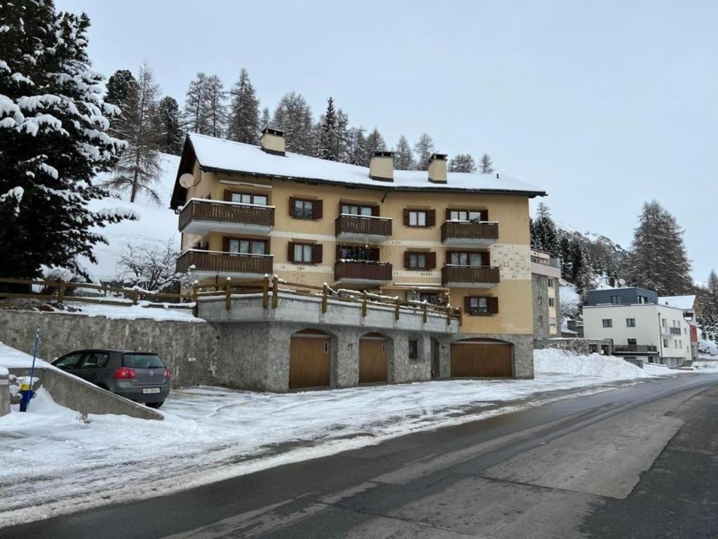 ein großes Apartmenthaus mit Auto im Schnee in der Unterkunft Chesa Florineth  Studio ÖV und Bergbahnen inklusive Sommer in Samedan
