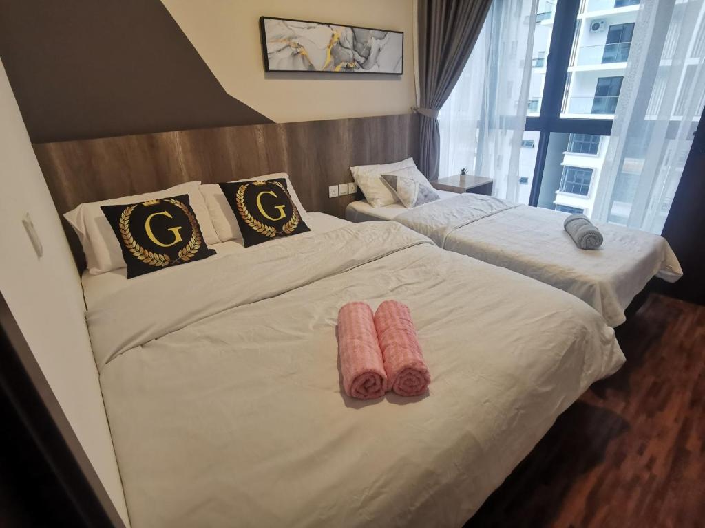 two beds in a hotel room with white sheets at K AVENUE B17 house room near airport by Gc in Kota Kinabalu