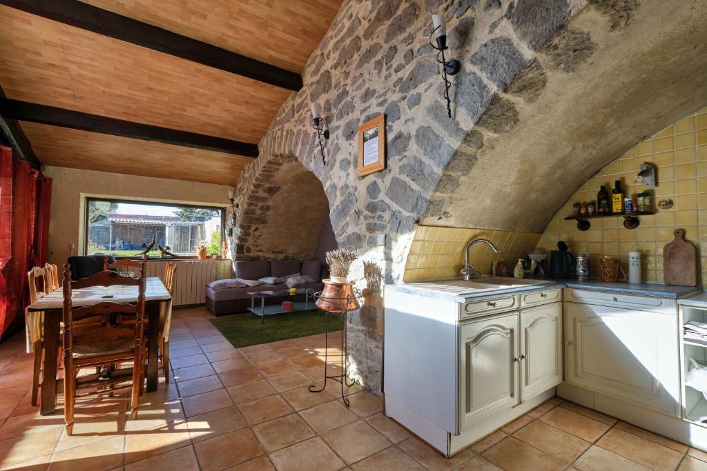 a kitchen and dining room with a stone wall at JARDIN STE ANNE in Carcassonne