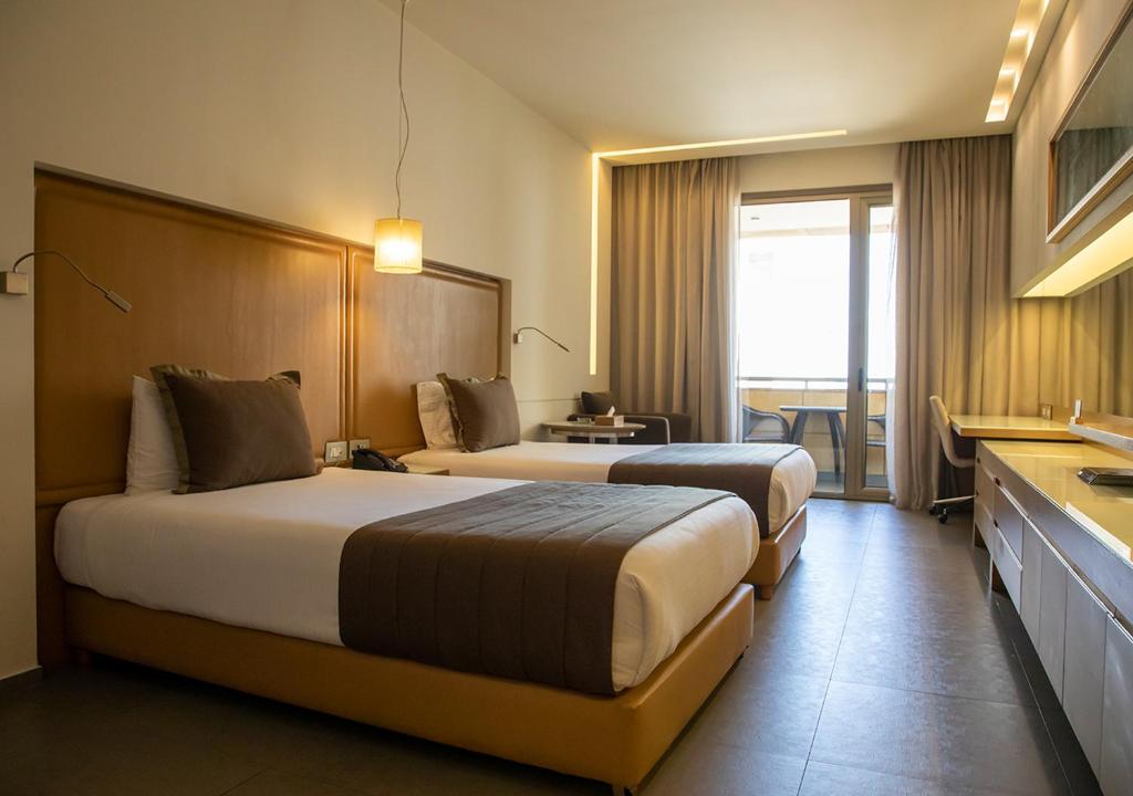 Postel nebo postele na pokoji v ubytování Saifi Suites Hotel
