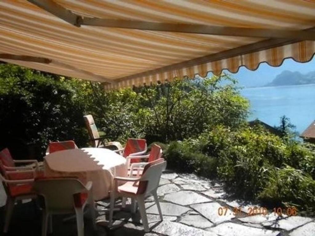 um pátio com uma mesa e cadeiras e o oceano em Ferienhaus in Quinten-Au em Quinten