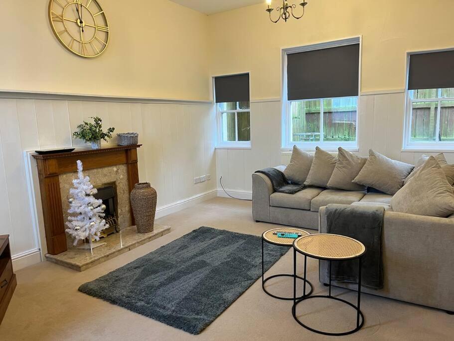 - un salon avec un canapé et une cheminée dans l'établissement Beautiful Countryside Cottage Alnwick, à Alnwick