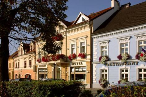un groupe de bâtiments avec des boîtes de fleurs sur eux dans l'établissement Hotel Restaurant Modrá Hvězda, à Dobřany